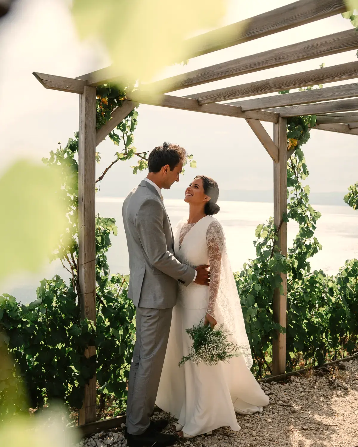 Un couple sous une pergola de vigne surplombant le lac
